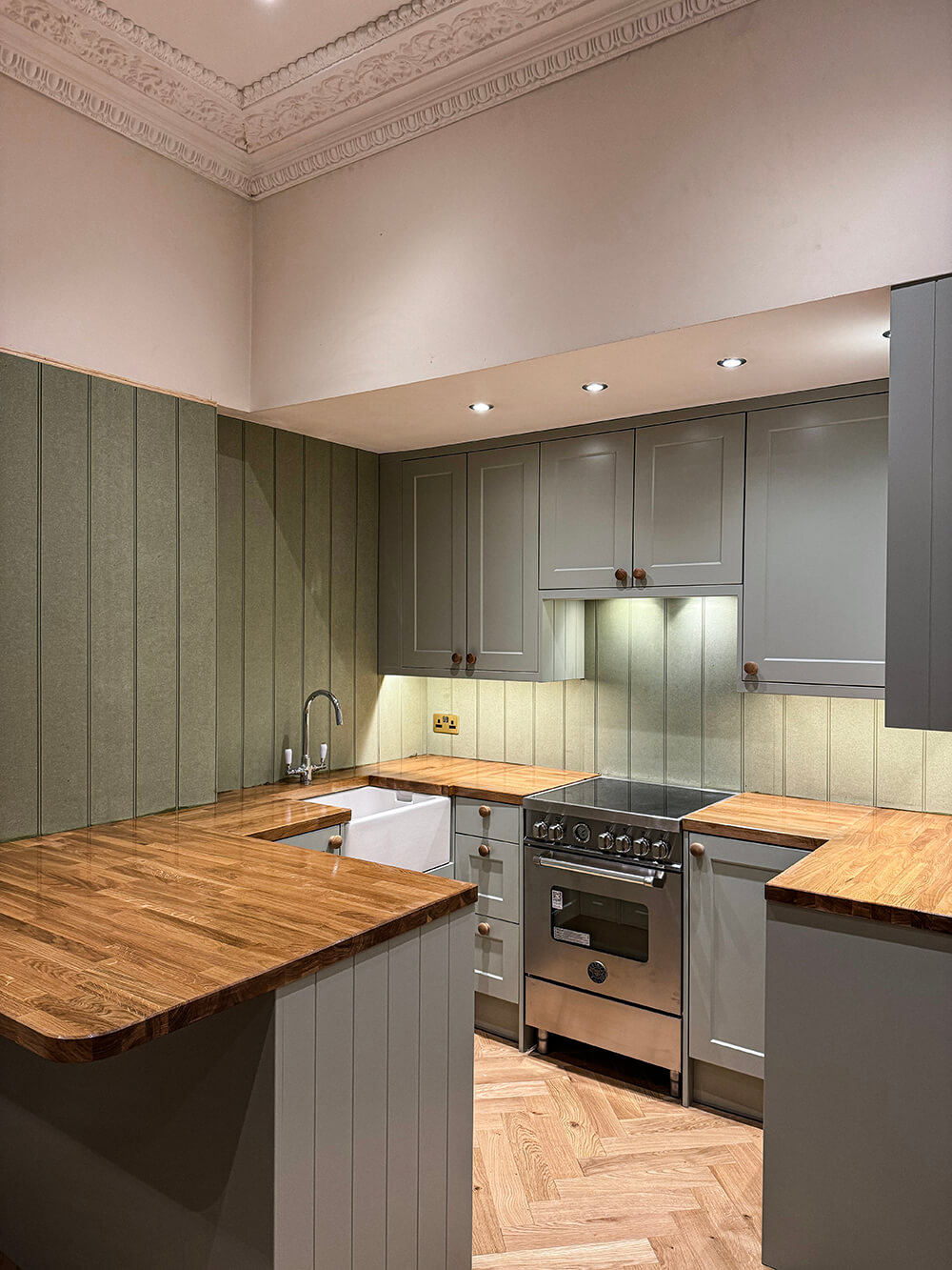 Kitchen after — bespoke sage cabinetry with oak worktops