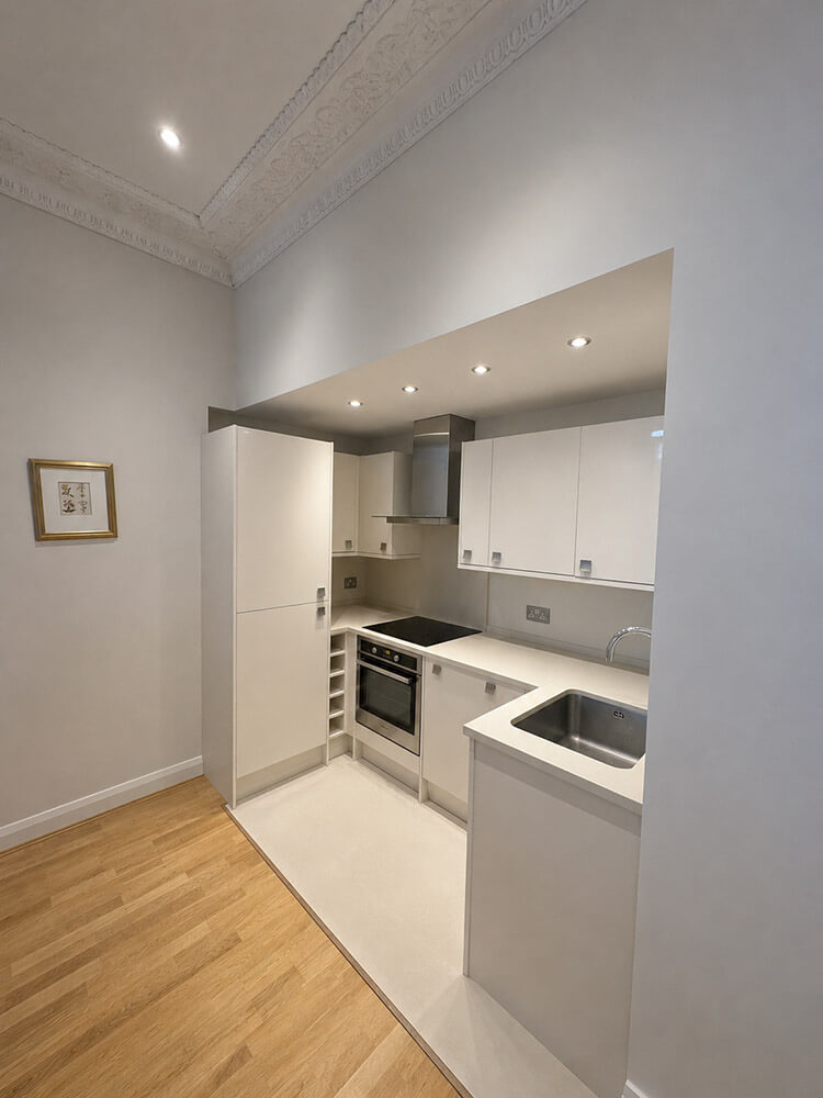 Kitchen before — dated white units with minimal character